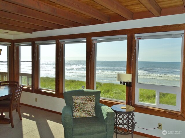 sunroom / solarium featuring beam ceiling, a water view, and wood ceiling