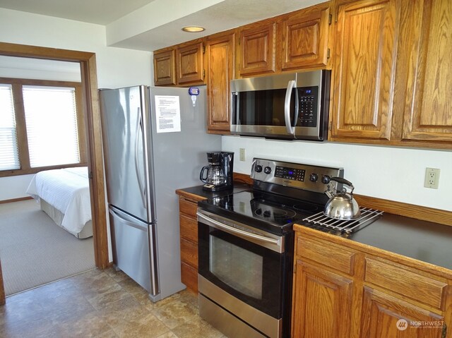 kitchen with stainless steel appliances and light colored carpet