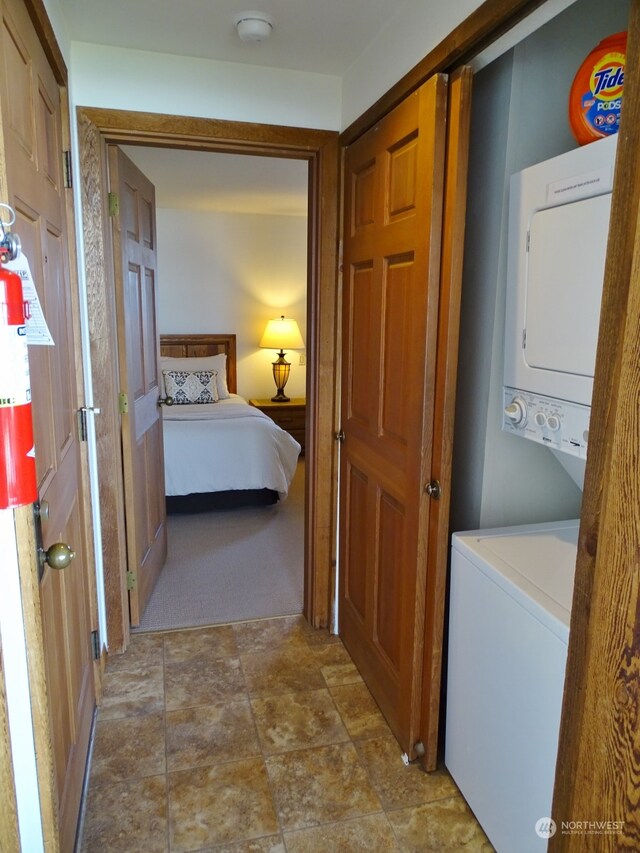 washroom featuring light carpet and stacked washer and dryer