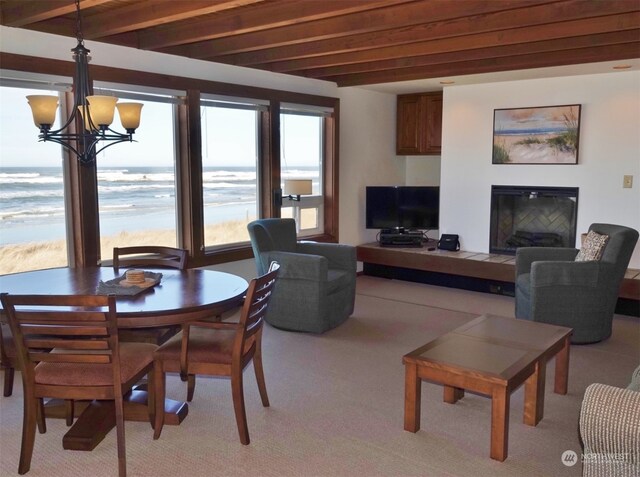 interior space with a water view, beamed ceiling, a chandelier, and light carpet