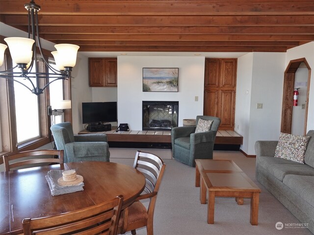 living room with light carpet, an inviting chandelier, and beam ceiling