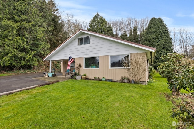 bungalow-style home featuring a front lawn and a patio area