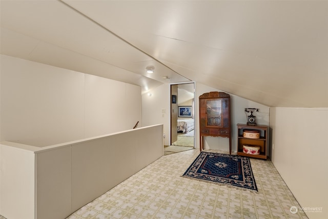 interior space with light carpet and lofted ceiling