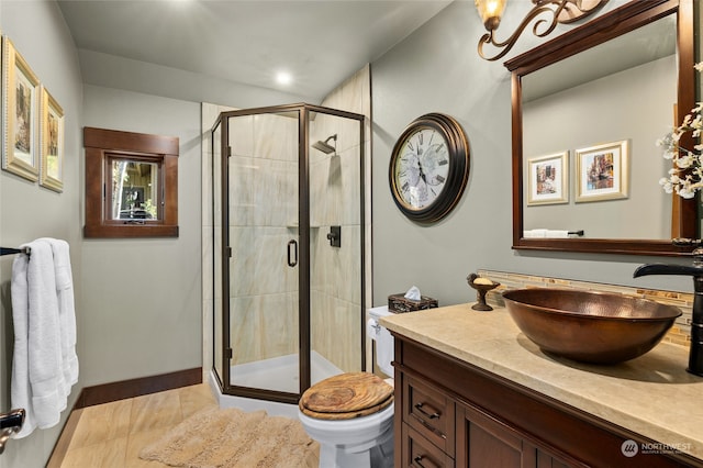 bathroom featuring tile floors, vanity, toilet, and a shower with door