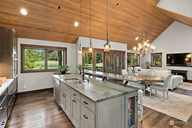kitchen featuring a kitchen island with sink, decorative light fixtures, a chandelier, and sink