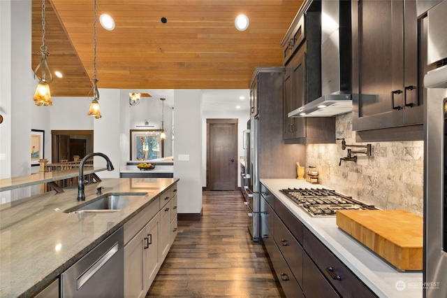 kitchen featuring decorative light fixtures, tasteful backsplash, wall chimney exhaust hood, dark hardwood / wood-style floors, and sink
