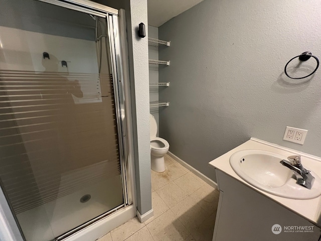 bathroom featuring a shower with door, toilet, tile flooring, and vanity