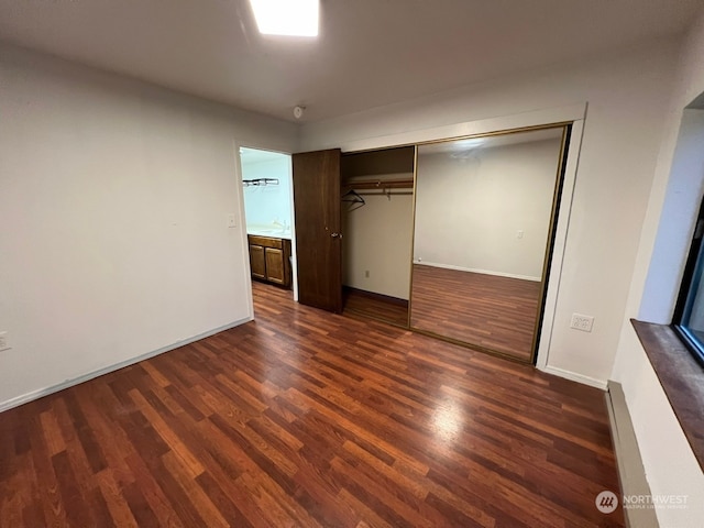 unfurnished bedroom featuring a closet and dark hardwood / wood-style floors