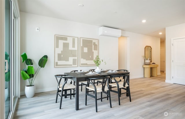 dining area with light wood-type flooring and a wall mounted AC