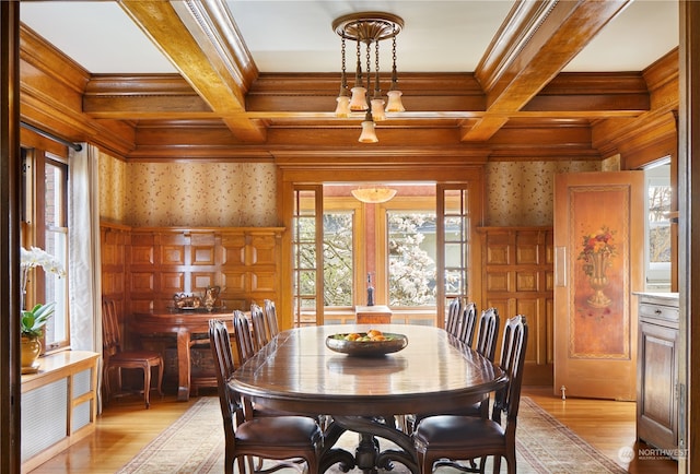 dining area featuring coffered ceiling, light hardwood / wood-style floors, and ornamental molding