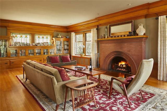 sitting room with ornamental molding, light hardwood / wood-style floors, a healthy amount of sunlight, and a fireplace