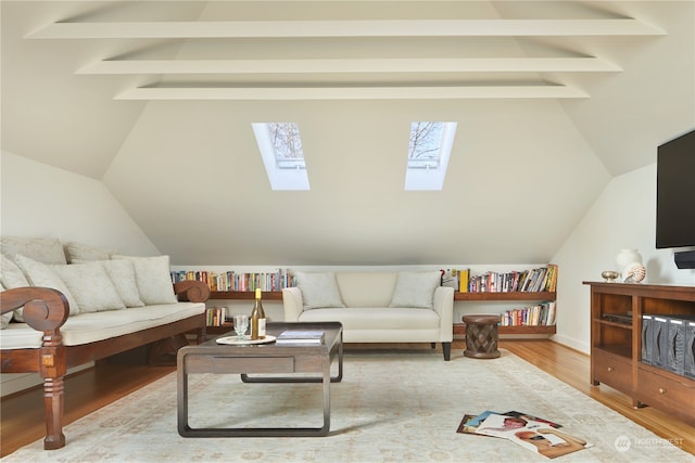 living room featuring vaulted ceiling with skylight and light hardwood / wood-style flooring