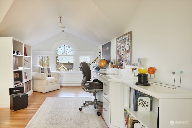 home office featuring lofted ceiling and light hardwood / wood-style flooring