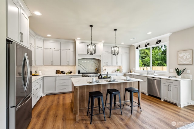 kitchen featuring dark hardwood / wood-style floors, a kitchen island, a kitchen bar, and appliances with stainless steel finishes