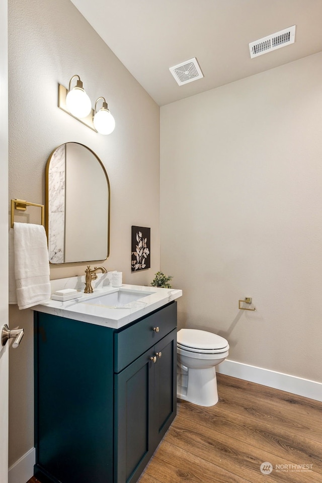 bathroom with hardwood / wood-style floors, vanity, and toilet