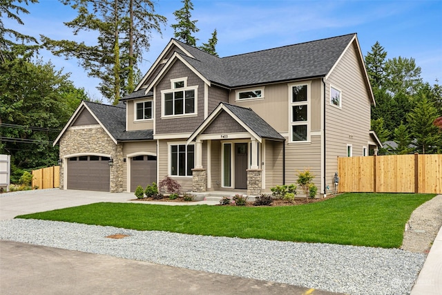 craftsman house featuring a garage and a front lawn