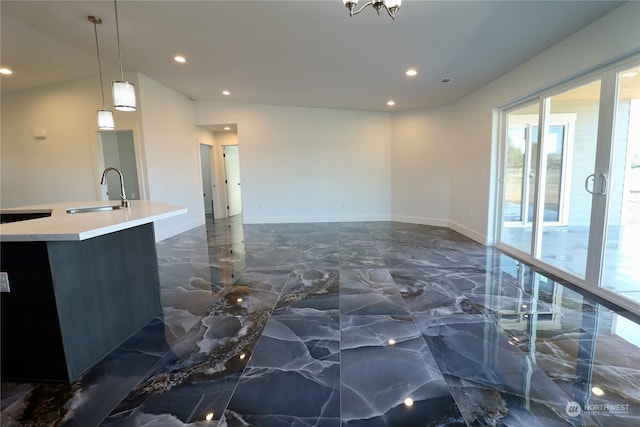 kitchen featuring decorative light fixtures, a kitchen island with sink, and sink