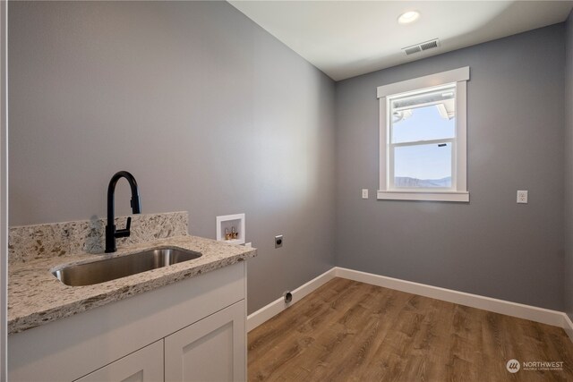 washroom featuring sink, hookup for an electric dryer, hookup for a washing machine, and light hardwood / wood-style floors