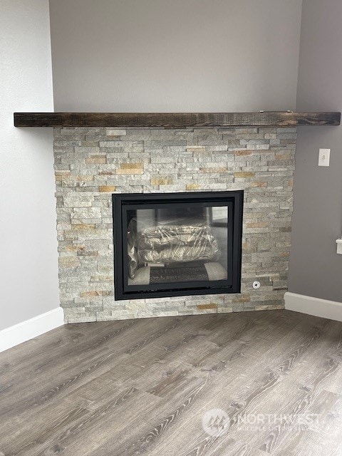 room details featuring hardwood / wood-style flooring and a stone fireplace