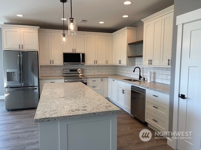 kitchen featuring sink, white cabinets, hanging light fixtures, dark hardwood / wood-style floors, and appliances with stainless steel finishes