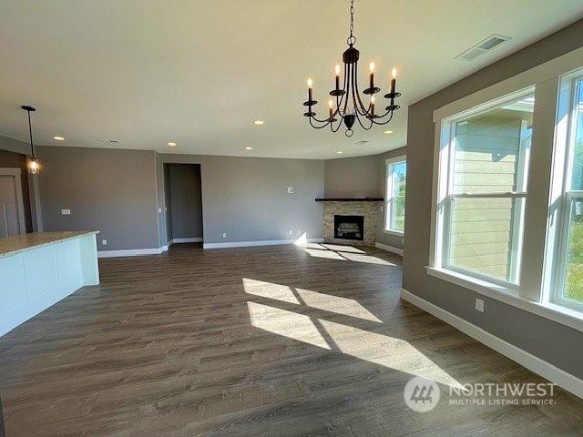 unfurnished living room with dark hardwood / wood-style flooring and a chandelier