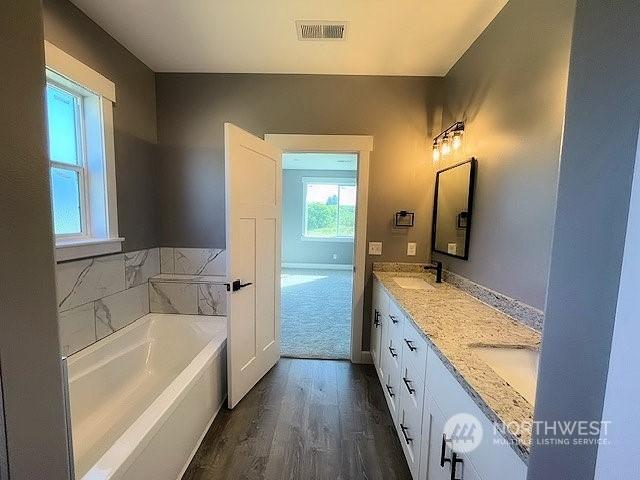 bathroom featuring hardwood / wood-style floors, vanity, and a bathing tub