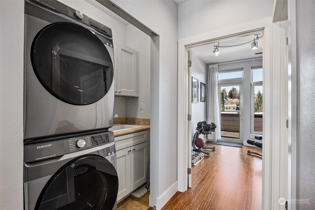 1501 Tacoma Ave S Unit 603, Tacoma, WA 98402 - washroom featuring cabinet space, stacked washer and clothes dryer, and wood finished floors