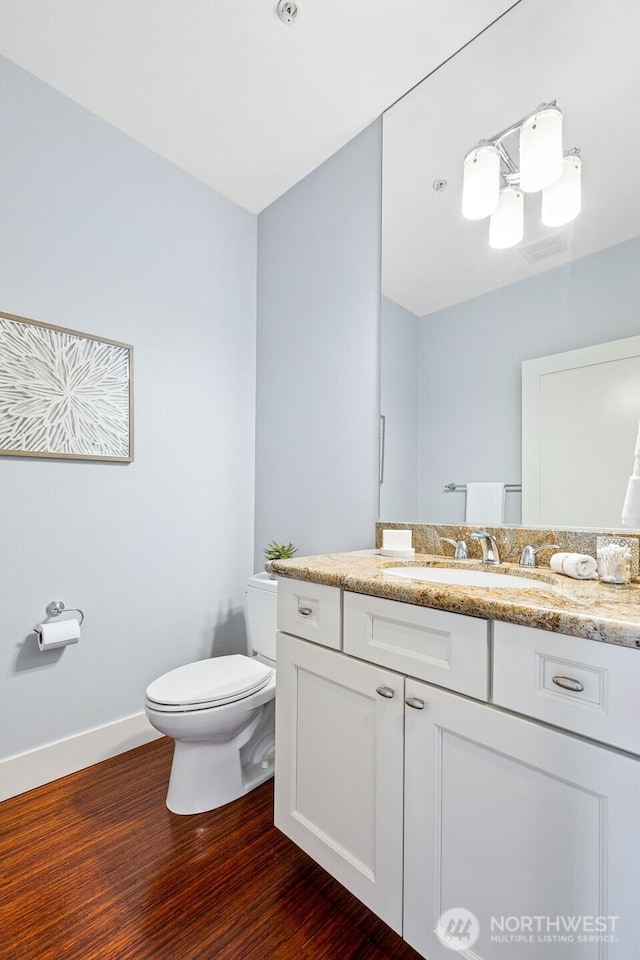 1501 Tacoma Ave S Unit 603, Tacoma, WA 98402 - bathroom with toilet, vanity, wood finished floors, and baseboards