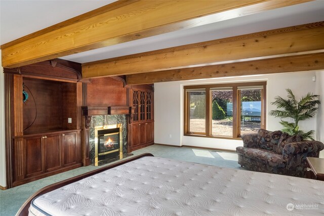 bedroom featuring beam ceiling, light carpet, and a premium fireplace