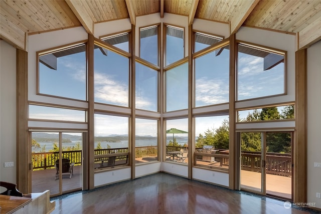 interior space with a water view, wood ceiling, and vaulted ceiling with beams