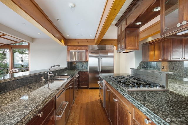 kitchen featuring dark stone counters, backsplash, dark wood-type flooring, and beamed ceiling