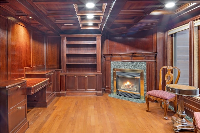 unfurnished office featuring crown molding, coffered ceiling, wooden walls, and light wood-type flooring