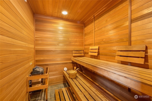 view of sauna / steam room with wooden walls, tile flooring, and wood ceiling