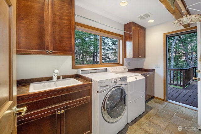 washroom with light tile floors, sink, cabinets, and independent washer and dryer