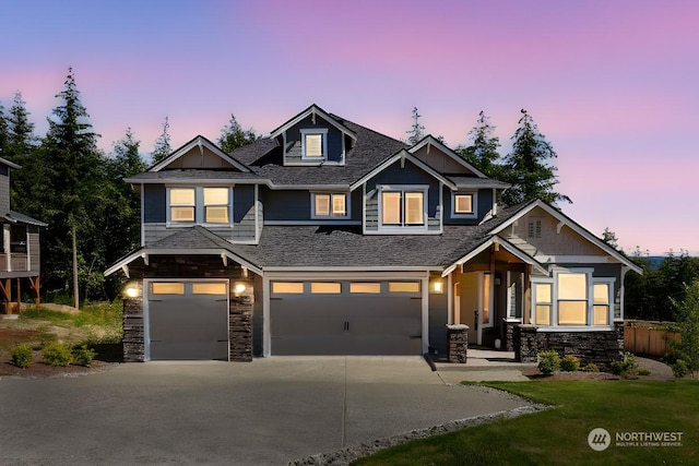 craftsman inspired home with stone siding, fence, an attached garage, and concrete driveway