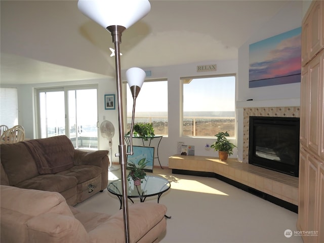 carpeted living room featuring a tiled fireplace