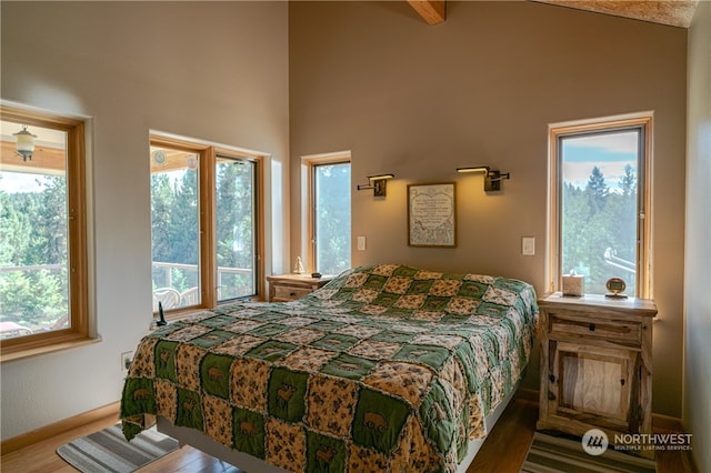 bedroom featuring dark hardwood / wood-style flooring and a towering ceiling