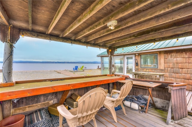 wooden terrace with exterior bar and a water view