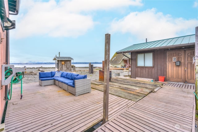 deck with outdoor lounge area and a water view