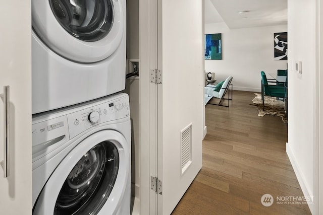 laundry room with stacked washer / drying machine, washer hookup, and light hardwood / wood-style floors