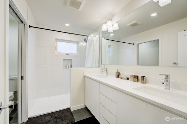 bathroom with tile floors, toilet, and double vanity