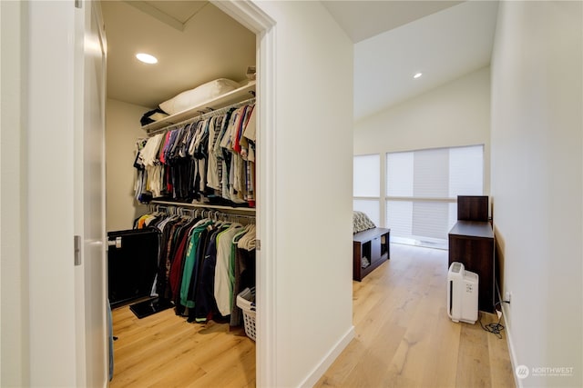 walk in closet with lofted ceiling and light hardwood / wood-style flooring