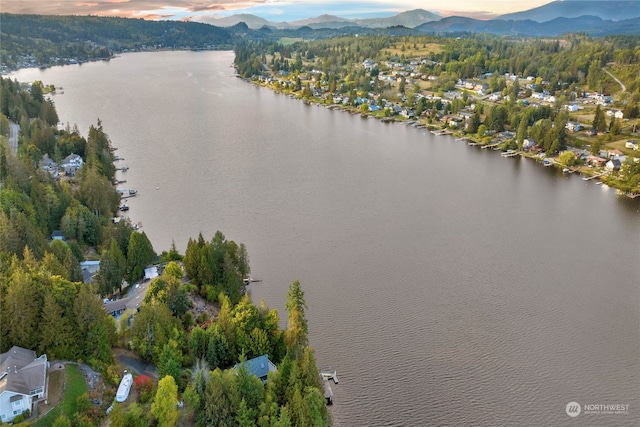 aerial view at dusk featuring a water and mountain view