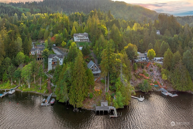 aerial view at dusk featuring a water view