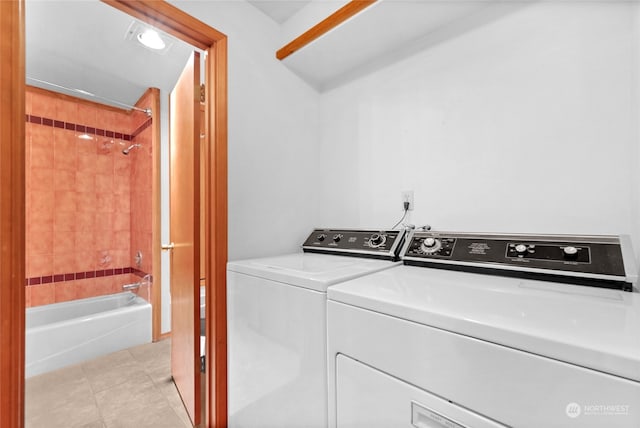 clothes washing area with light tile floors and washing machine and clothes dryer