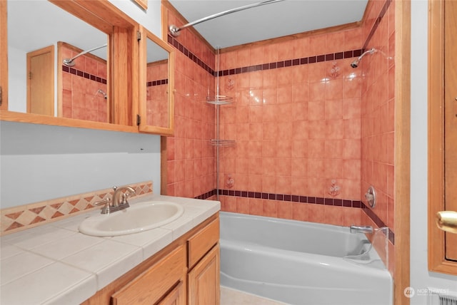 bathroom featuring tiled shower / bath combo and vanity