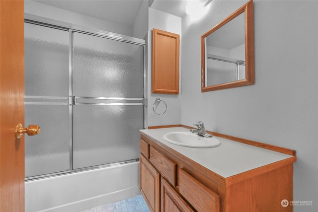 bathroom featuring combined bath / shower with glass door, tile flooring, and vanity with extensive cabinet space