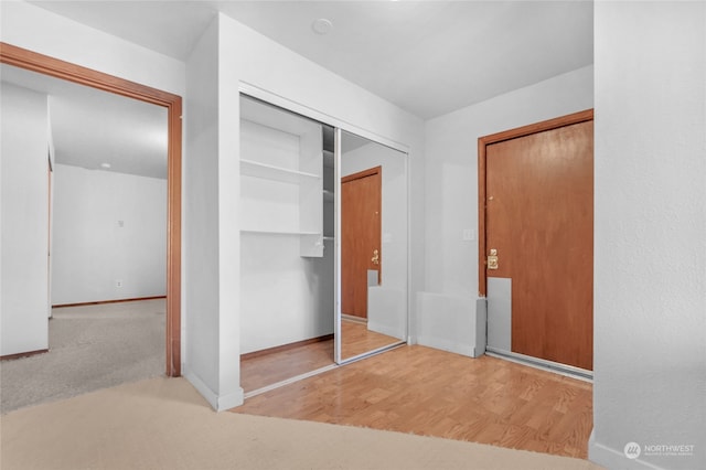 unfurnished bedroom featuring a closet and light colored carpet