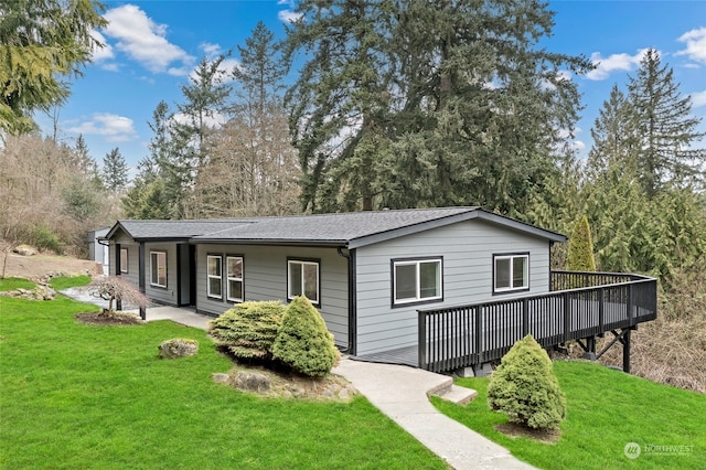 single story home featuring a wooden deck and a front lawn