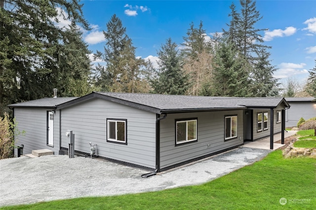 back of property with a patio and a lawn